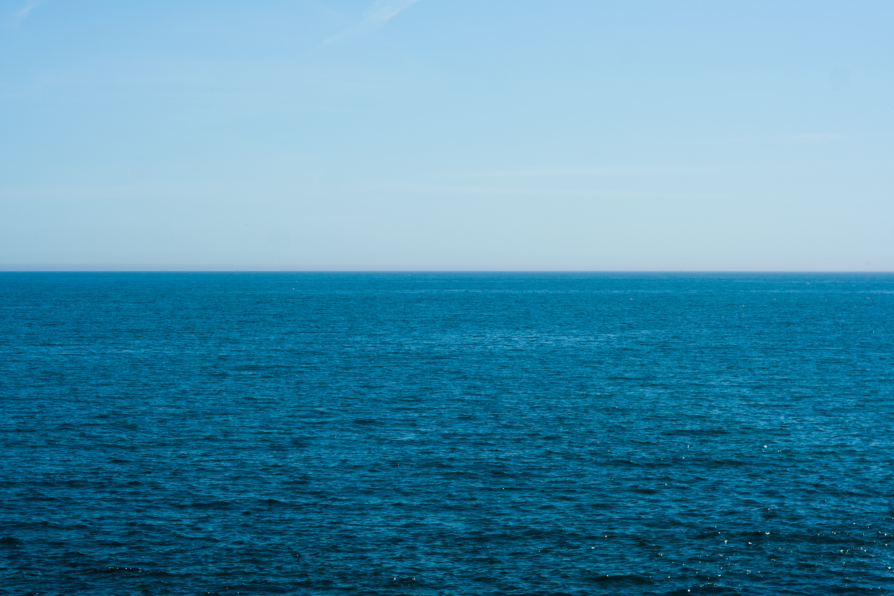 A calm, blue sea and cloudless sky