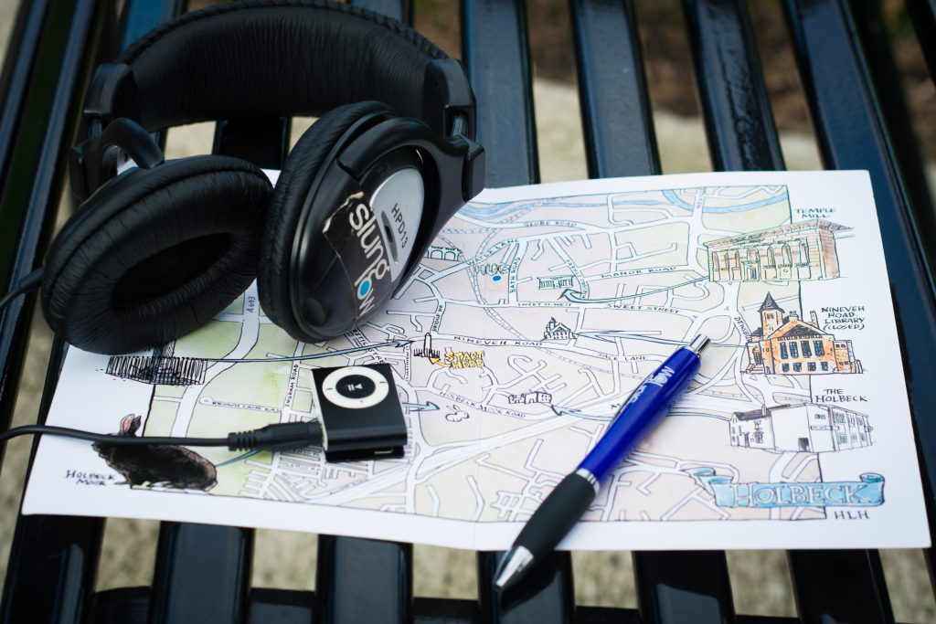 A Map of Holbeck, a Pen and an MP3 Player with Headphones on a Bench